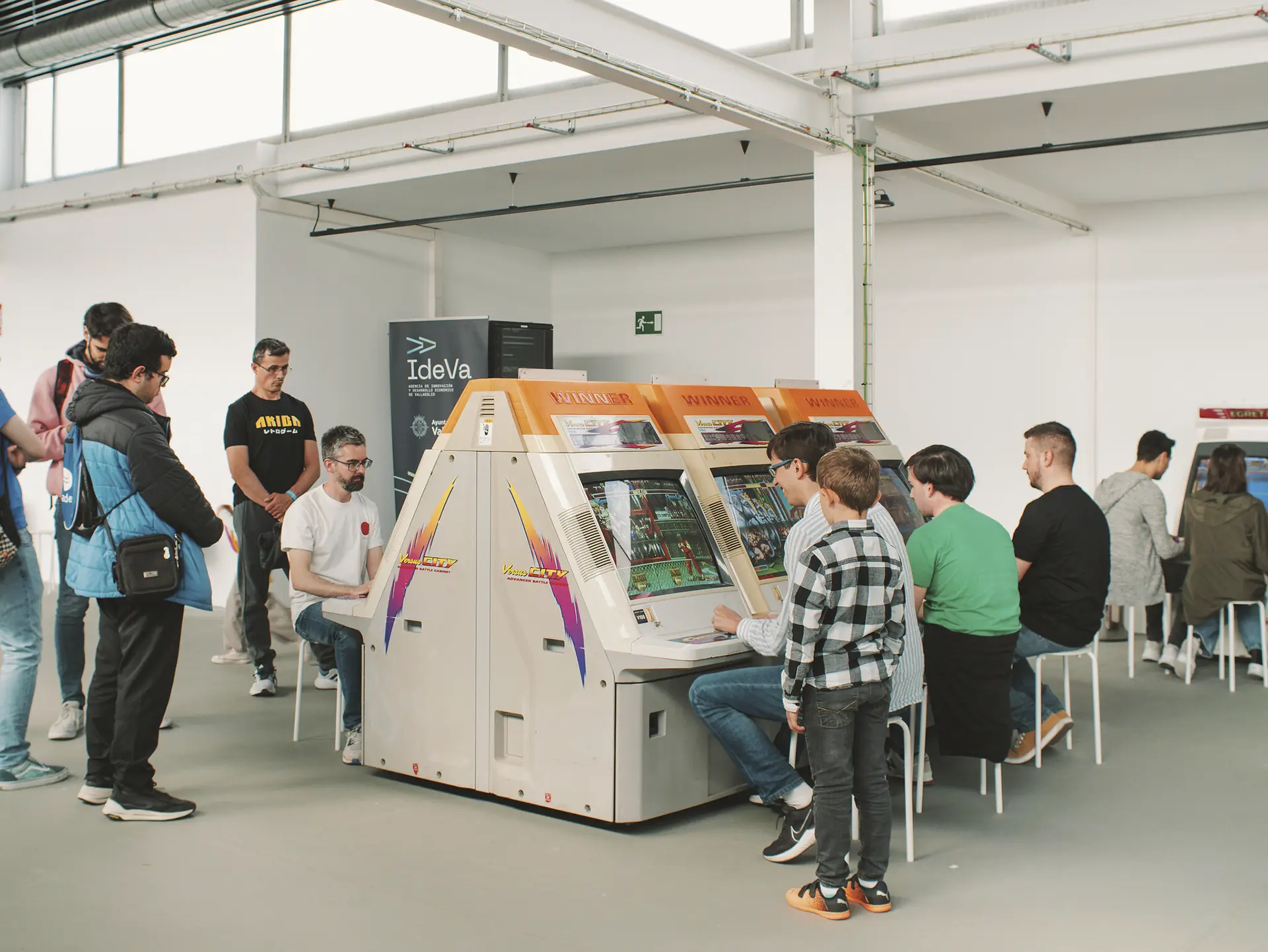 NIños y adultos jugando a maquinbas arcade